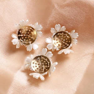Dettaglio di accessori per gioielli a fiori di perle su sfondo di seta champagne