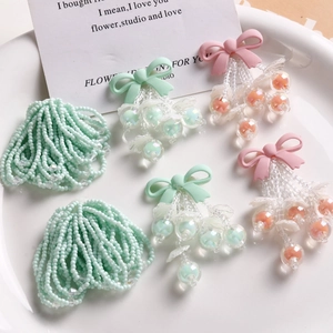 Detailed macro view of handmade pink and green beaded bow charms for DIY jewelry crafting