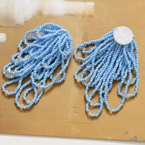 Macro view of blue crystal flower tassel earrings with intricate handmade beadwork