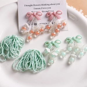 Detailed view of handmade pink bow tassel earrings and matching DIY craft beads