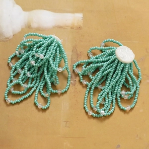 Detail view of handmade mint green beaded tassels for DIY floral jewelry making