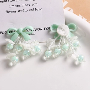 Handmade lily of the valley hair accessories with green bows and iridescent beaded tassels