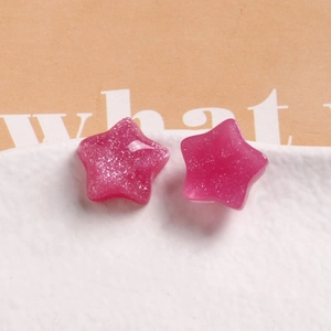 Macro shot of hot pink glitter resin star pendants for DIY earrings and phone cases