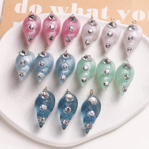Macro detail of pastel resin seashell pendants with rhinestones for DIY jewelry making