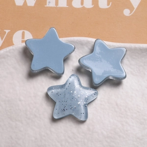 Macro shot of resin star charms in macaron blue and glitter finishes for DIY crafts