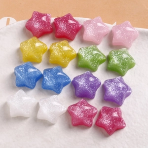 Flat lay of colorful resin star beads with glitter finish on a white textured tray