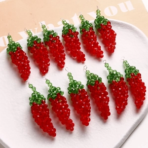 Macro shot of twelve handmade red chili glass bead pendants for DIY jewelry making
