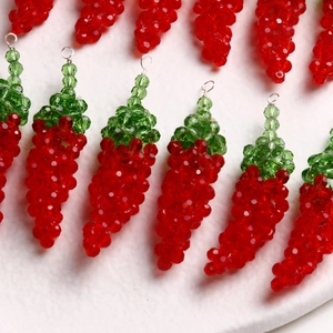 Macro shot of handmade red and green chili pepper glass beaded charms for DIY jewelry making