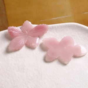 Close-up of translucent pink resin cherry blossom flower charms for DIY jewelry making