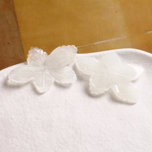 Close-up of translucent white five-petal flower resin charms for DIY jewelry