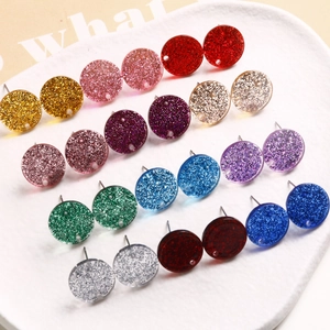 Close-up of colorful round glitter earrings with shimmering silver foil in variety of shades