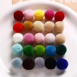Flat lay of 25 colorful 20mm plush pom-poms on a white plate for DIY jewelry making
