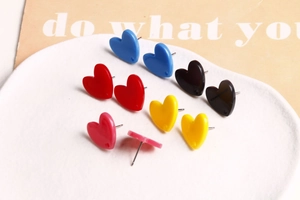 Vue détaillée des boucles d'oreilles cœur en acrylique rouge, bleu, rose et jaune