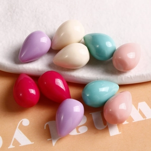 Colorful resin teardrop beads for DIY jewelry making displayed on a ceramic plate