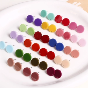 Flache runde Acryl-Ohrstecker in verschiedenen lebhaften Farben in einer Keramikschale