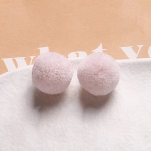 Close-up of soft light pink 20mm plush pom-poms for DIY jewelry and hair accessories
