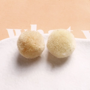 Close-up of 20mm soft beige plush round balls for DIY jewelry and hair accessory crafts