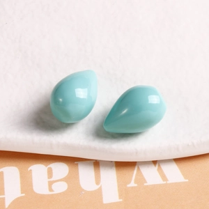 Macro shot of two light blue teardrop resin pendants with a polished mirror finish for DIY