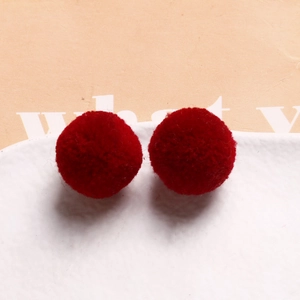 Detail shot of fluffy dark red plush round balls for DIY jewelry and hair accessories