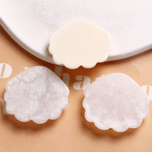 Gros plan de charms coquillages en résine avec fini nacré et textures pailletées