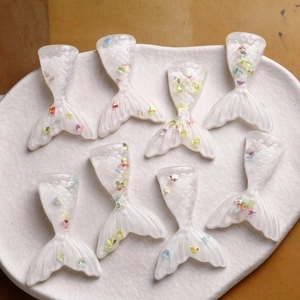 Translucent resin mermaid tail DIY accessories with colorful laser sequins on white tray