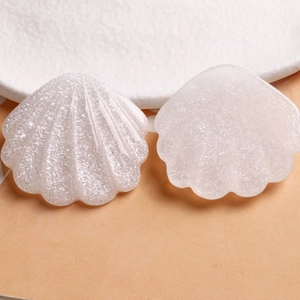 Détail de breloques coquilles Saint-Jacques en résine avec finition blanc nacré