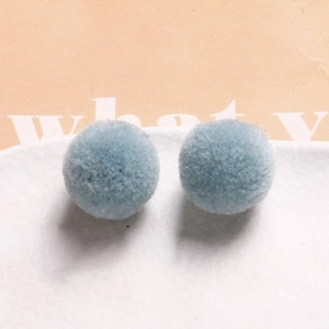 Detail view of two soft 20mm light blue plush pom-pom balls for DIY jewelry and crafts