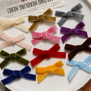 Detail of velvet ribbon bows in eleven vibrant colors arranged in a white tray