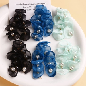 Handmade tulle mesh flower petals with pearls for jewelry making in a ceramic dish