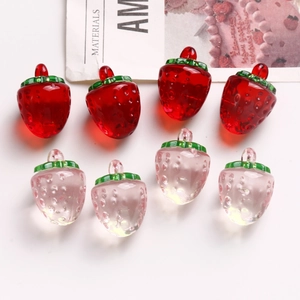 Détail macro de breloques fraises en résine transparente rouge et rose pour bijoux DIY