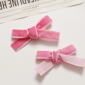 Close-up of pink velvet ribbon hair clips with elegant double-layered bow design