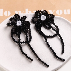 Detailed view of handmade black beaded flower accessories with elegant dangling tassels