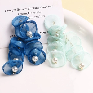 Detail view of handmade mesh flower petal pendants with pearls in navy and mint green