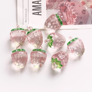 Vue détaillée de huit pendentifs fraise en acrylique rose translucide avec crochets feuilles