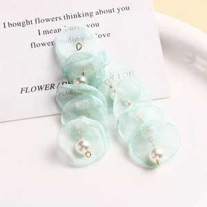 Detail of mint green mesh flower charms with pearls and gold loops for DIY jewelry