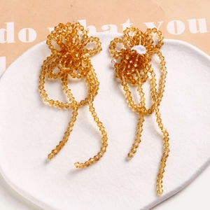 Close-up of amber handmade woven glass beaded long tassels for earrings and DIY accessories