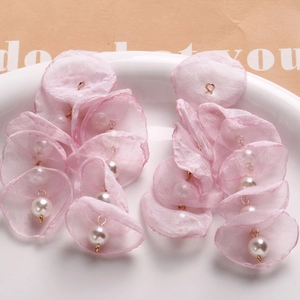 Detail of pink organza flower petal earrings with white pearls and gold metal links