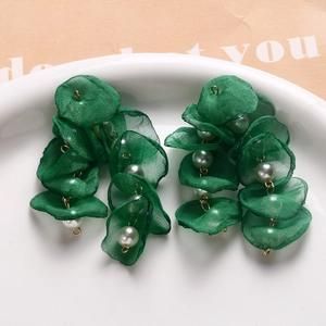 Detail of emerald green mesh fabric flower petals and pearls on floral jewelry accessory