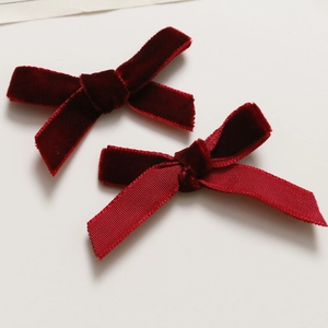 Detail of burgundy velvet ribbon bows and textured handmade hair clip DIY accessories