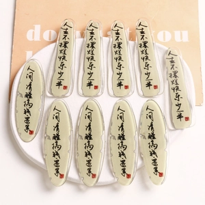 Acrylic jewelry patches with Chinese calligraphy on a ceramic tray for DIY accessories