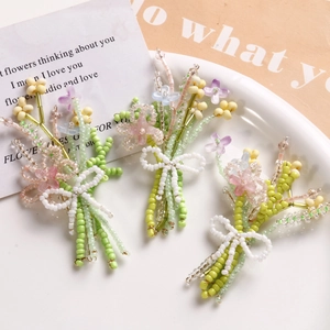Detail of handmade beaded flower accessories with a white bow in elegant ceramic plate