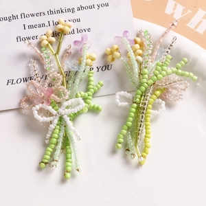 Macro shot of handmade beaded flower bouquet brooches with delicate white bow details
