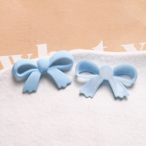 Détail macro de charmes de nœud en résine bleu clair mats et translucides pour bijoux
