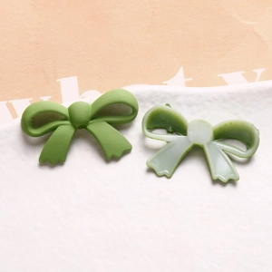 Vue détaillée des breloques nœuds en résine vert mat pour accessoires de bijoux DIY