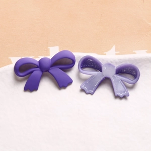 Détail de pendentifs nœuds en acrylique violet avec textures mates et translucides DIY
