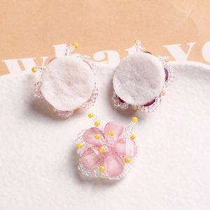 Detail of handmade beaded flower accessories with pink petals and white felt backing