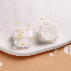 Detail of handmade beaded flower charms with white sequins and yellow glass beads