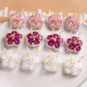 Detail of 12 handmade glass bead flower charms in pink, purple, and white for DIY jewelry