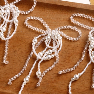 Macro shot of handmade bow charms with clear faceted beads and faux pearl tassels