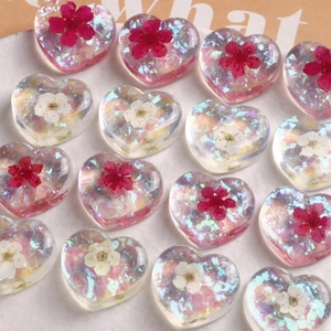 Colorful clear resin heart charms with dried flowers and holographic flakes for DIY crafts